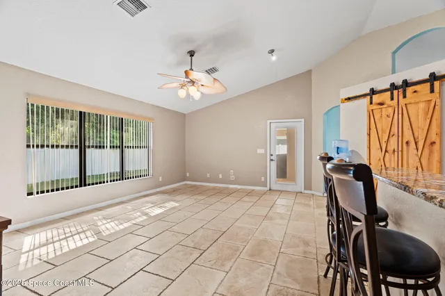 a view of a livingroom with lounge chair and a large window