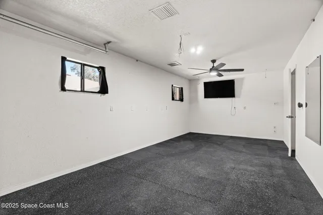 a view of an empty room with a ceiling fan