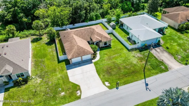 an aerial view of house with yard and swimming pool