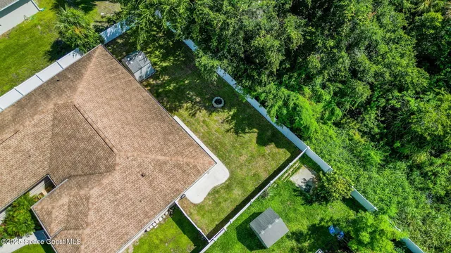 an aerial view of a house with a yard and lake view