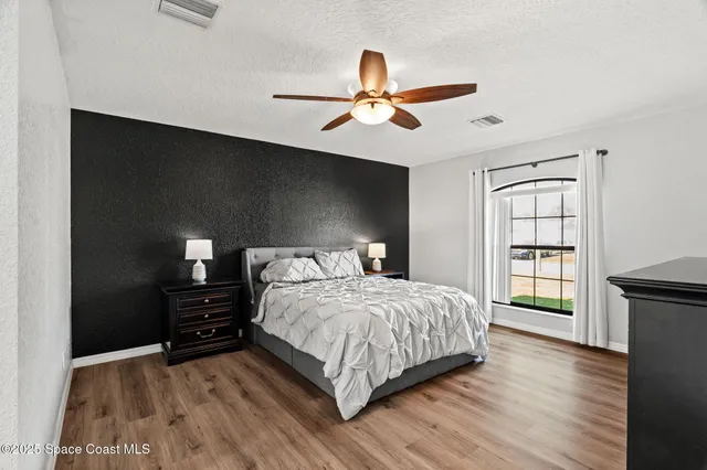 a bedroom with a bed and wooden floor