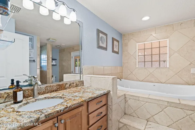 a bathroom with a granite countertop sink and a mirror