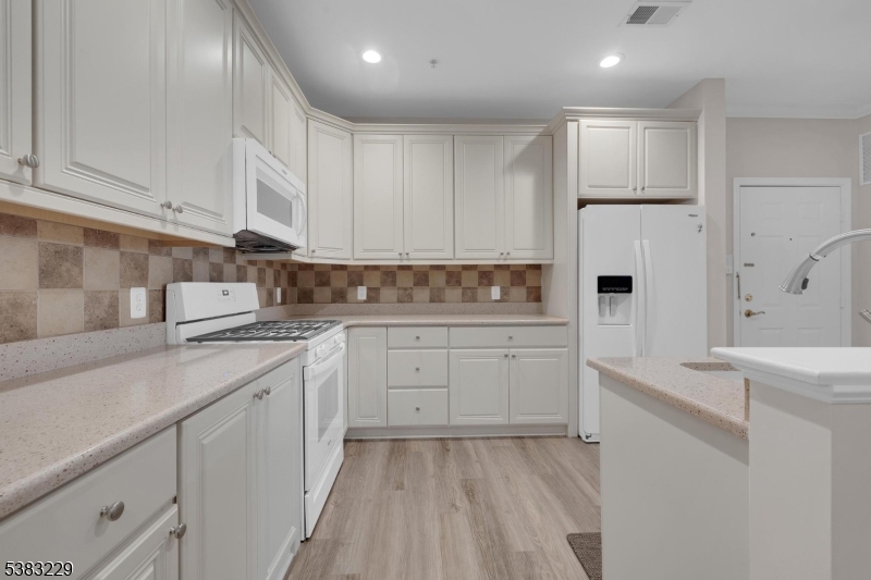 a kitchen with white cabinets and white appliances