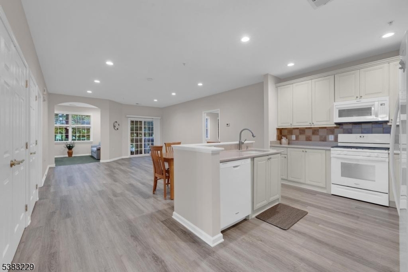 7 Ridgeview Lane, Unit 7 Mount Arlington, NJ 07856 - Photo 14 of 33 a kitchen with wooden floors and white appliances