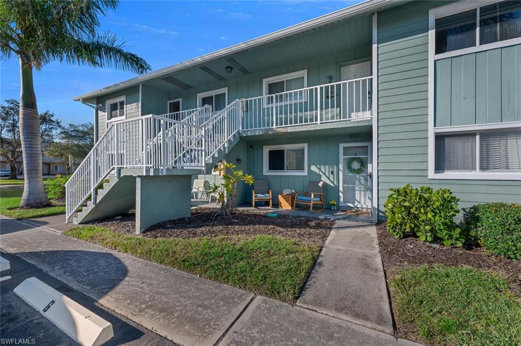 154 Cypress Way East, Unit 1102 Naples, FL 34110 - Photo 11 of 12 a front view of a house with garden