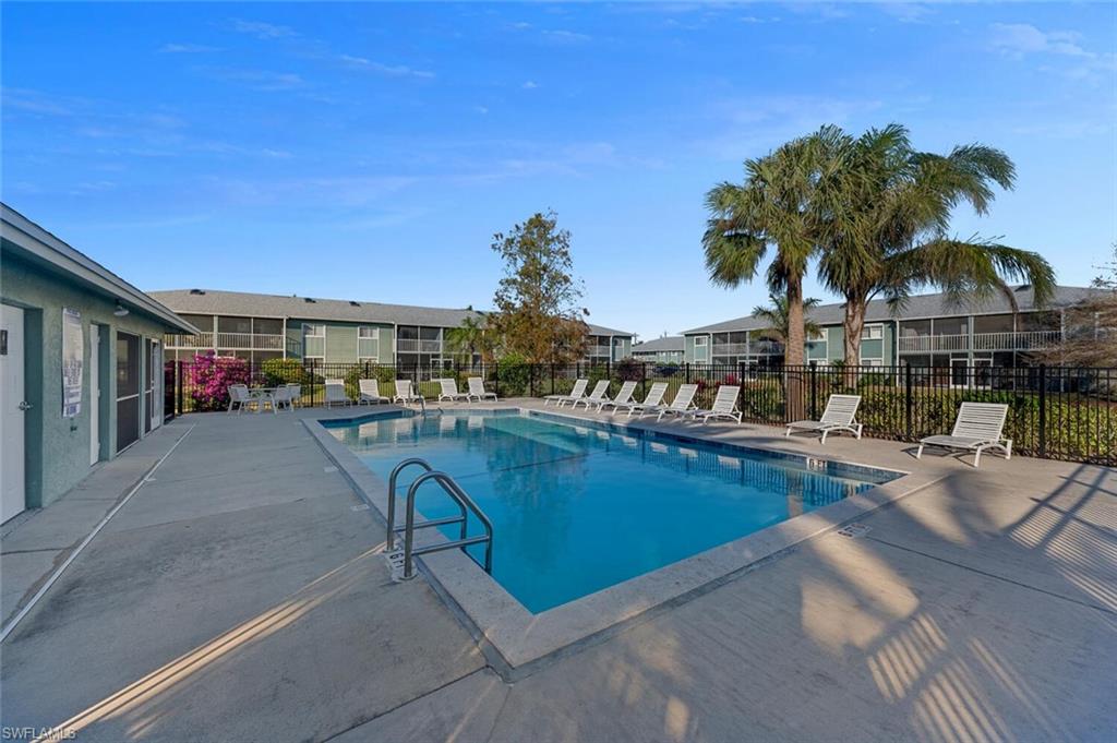 154 Cypress Way East, Unit 1102 Naples, FL 34110 - Photo 12 of 12 a swimming pool view with a outdoor seating