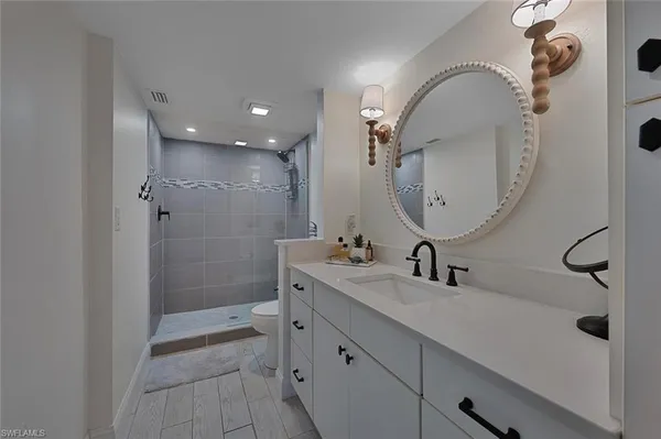 a bathroom with a double vanity sink mirror and shower