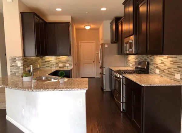 a kitchen with stainless steel appliances granite countertop a sink and a stove