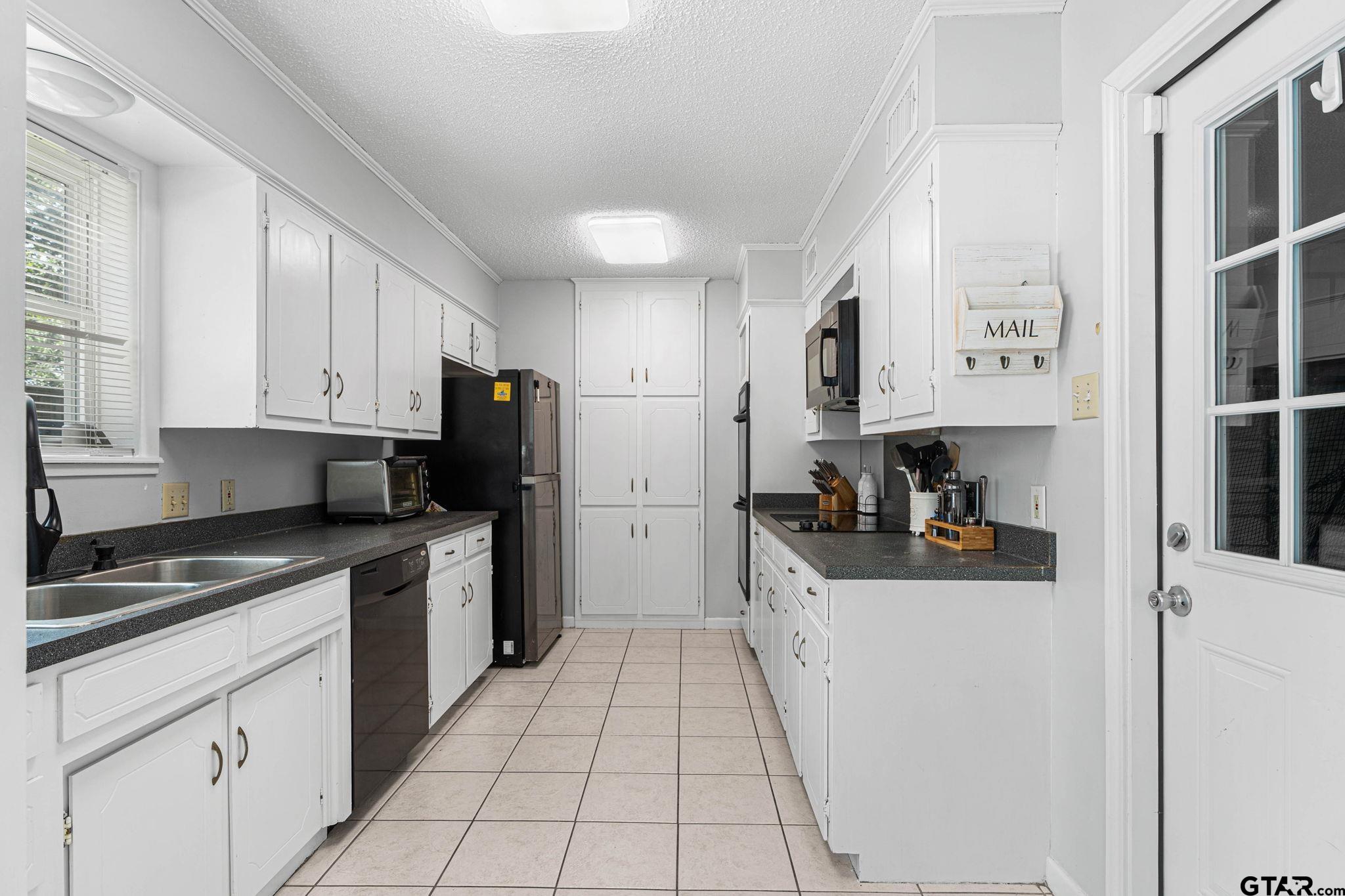 8224 Purdue Drive Tyler, TX 75703 - Photo 13 of 39 a kitchen with stainless steel appliances a refrigerator sink and cabinets
