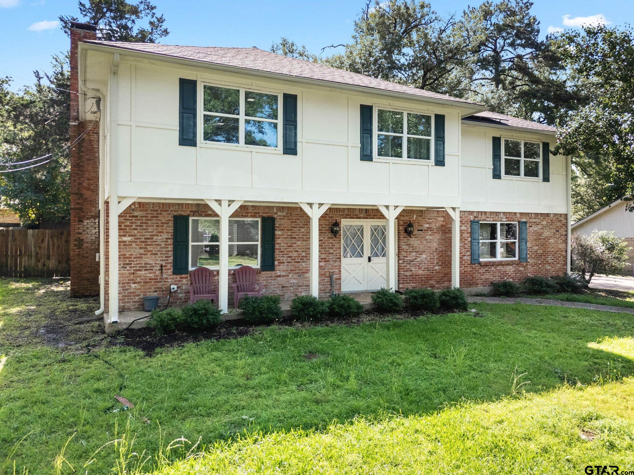 8224 Purdue Drive Tyler, TX 75703 - Photo 2 of 39 a front view of a house with a garden and yard