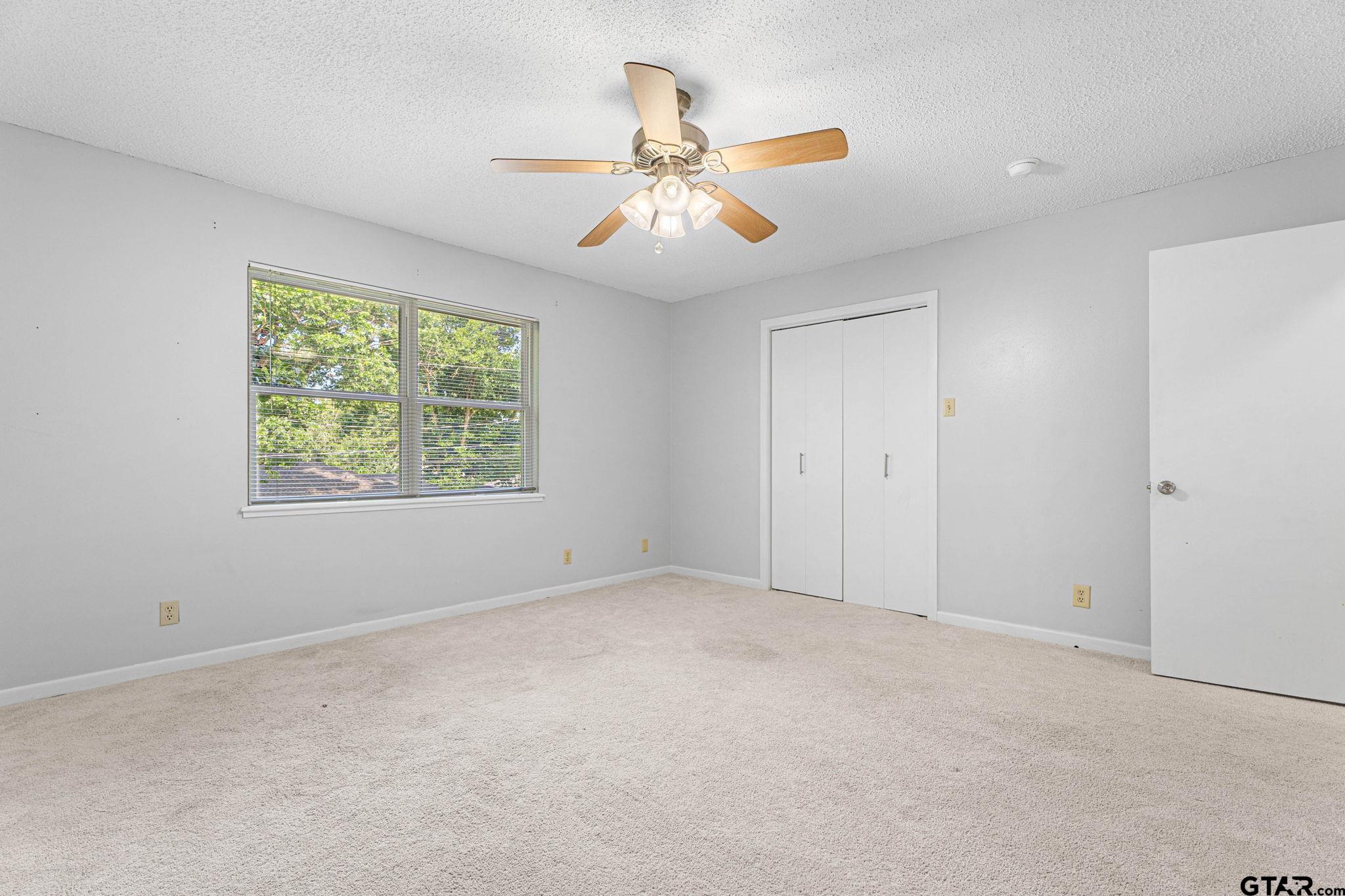 8224 Purdue Drive Tyler, TX 75703 - Photo 24 of 39 an empty room with windows and fan