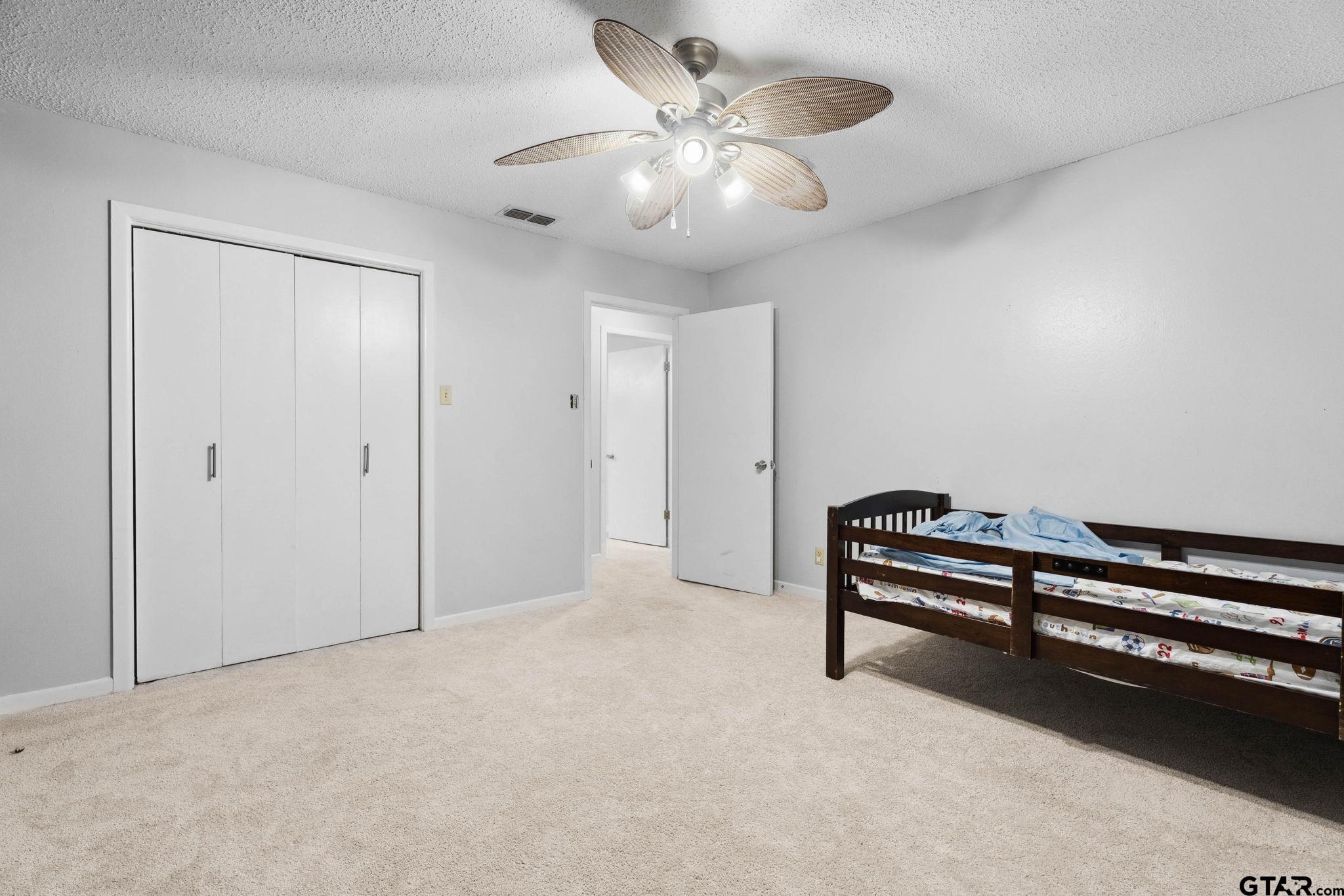 8224 Purdue Drive Tyler, TX 75703 - Photo 25 of 39 a view of an empty room with a chandelier fan