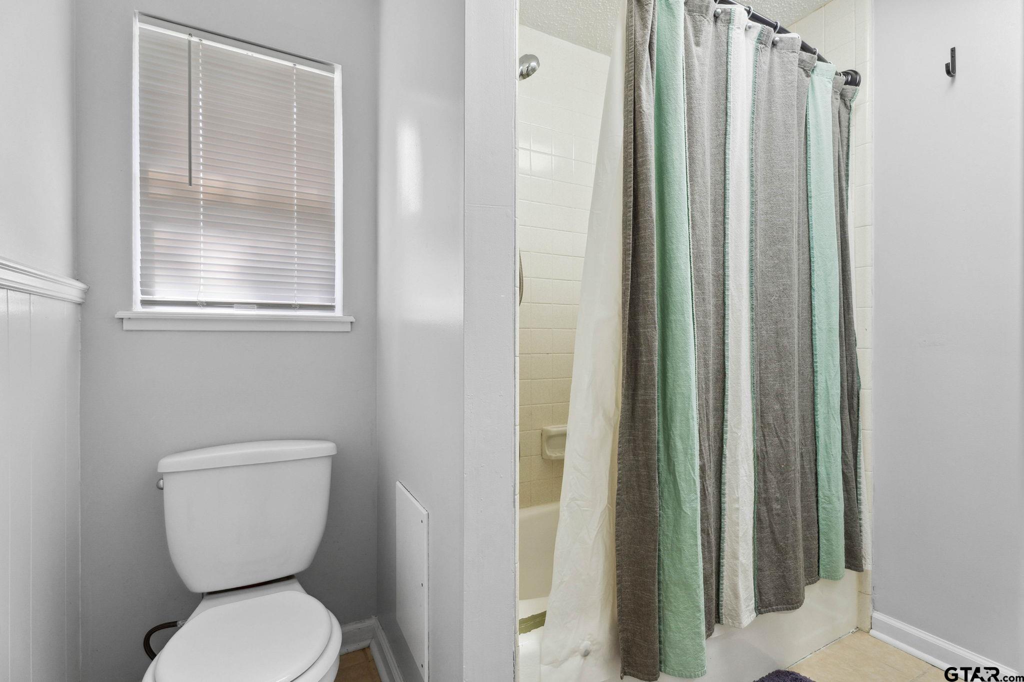 8224 Purdue Drive Tyler, TX 75703 - Photo 28 of 39 a bathroom with a toilet and a shower curtain