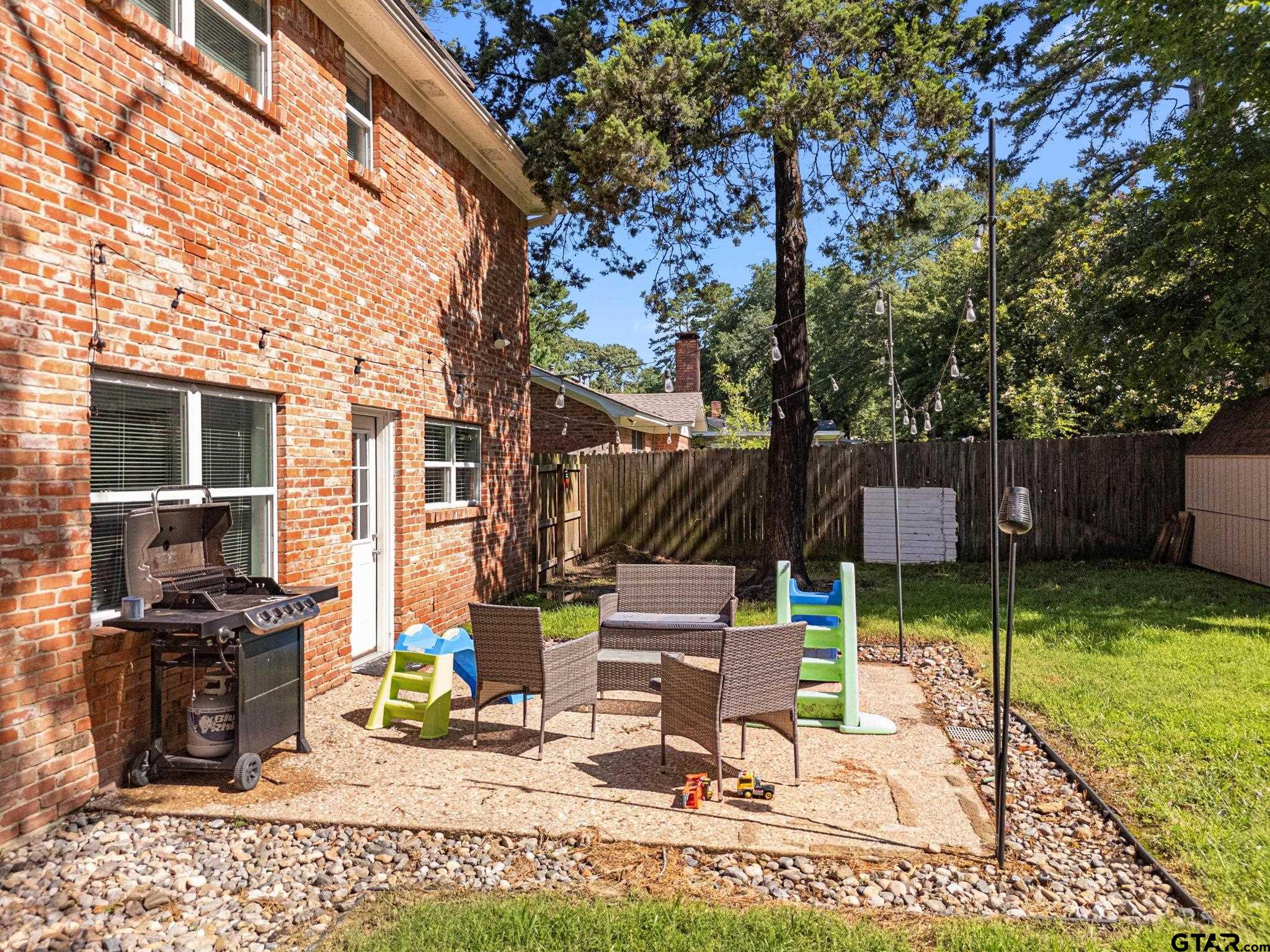 8224 Purdue Drive Tyler, TX 75703 - Photo 35 of 39 a view of backyard with a table and chairs under an umbrella