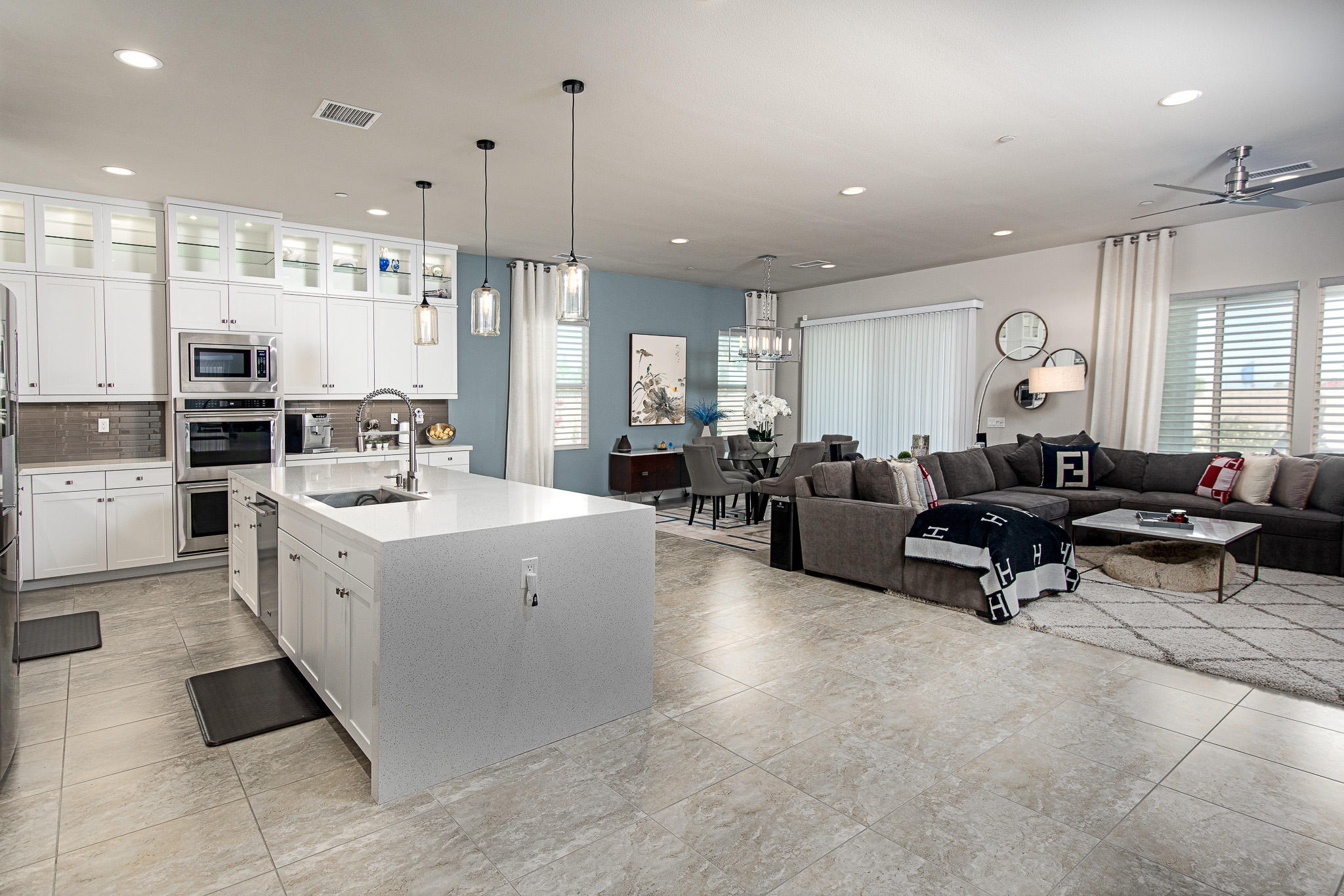 a large white kitchen with a large window and stainless steel appliances