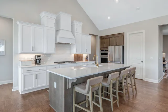 a kitchen with white cabinets and appliances