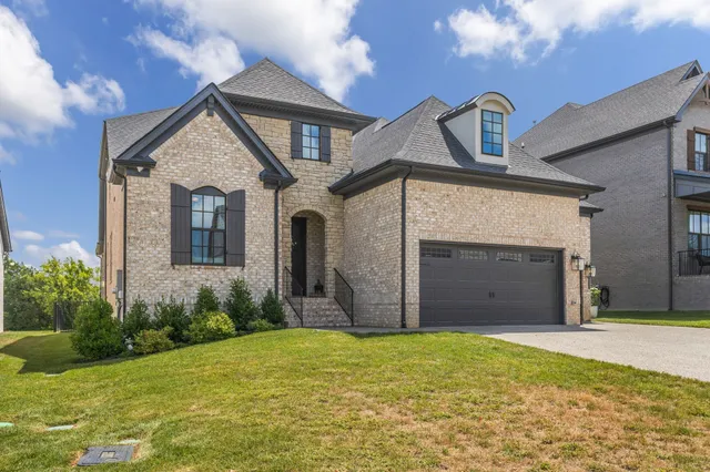 a view of a house with a yard and garage