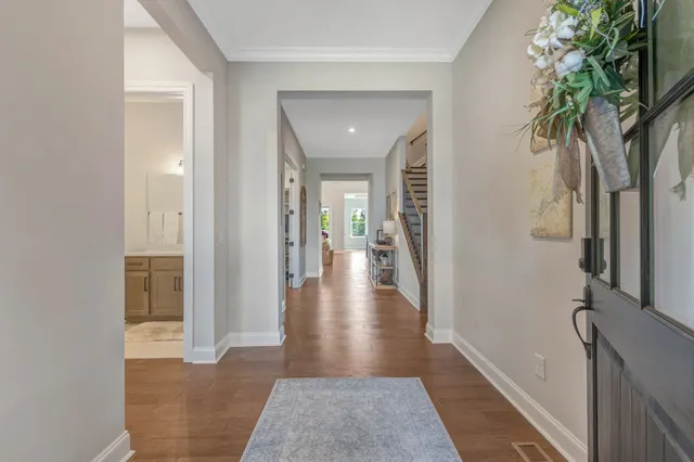 a view of a hallway with wooden floor and a living room