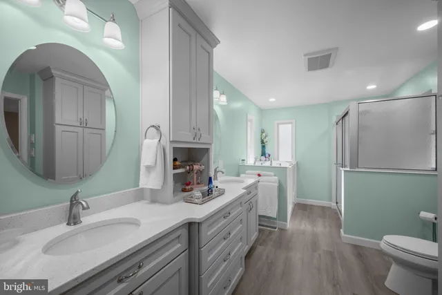 a bathroom with a double vanity sink mirror and toilet