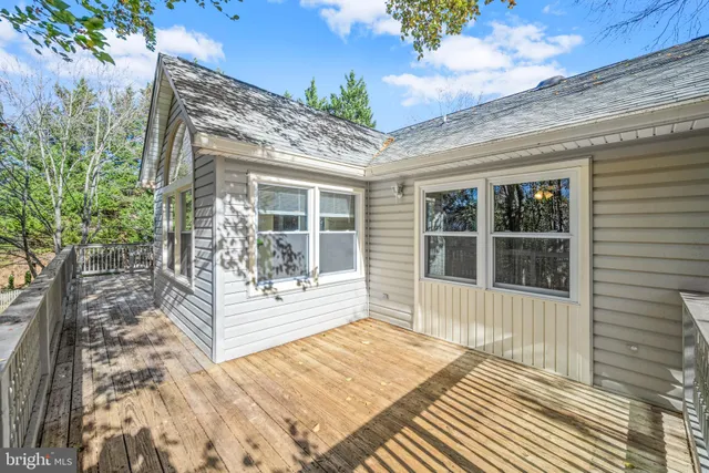 a view of a house with a large window and wooden fence
