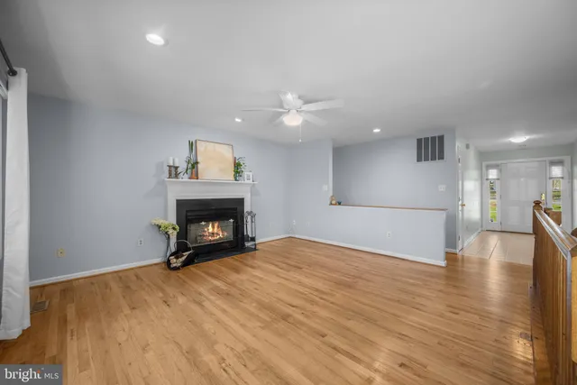 a view of empty room with wooden floor and fireplace