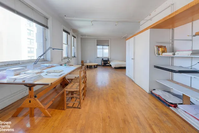 a spacious bedroom with a bed and wooden floor