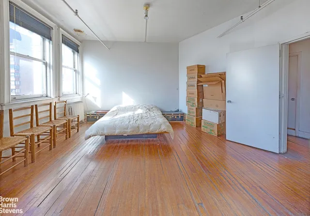 a living room with a bed furniture and a window