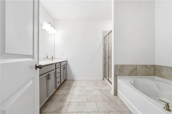 a bathroom with a tub a sink and a shower