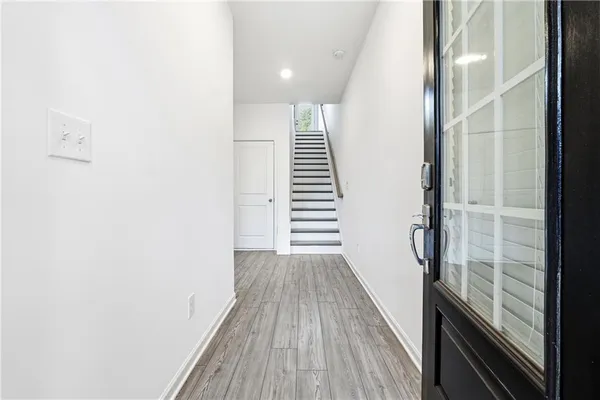 a view of a hallway with wooden floor and staircase