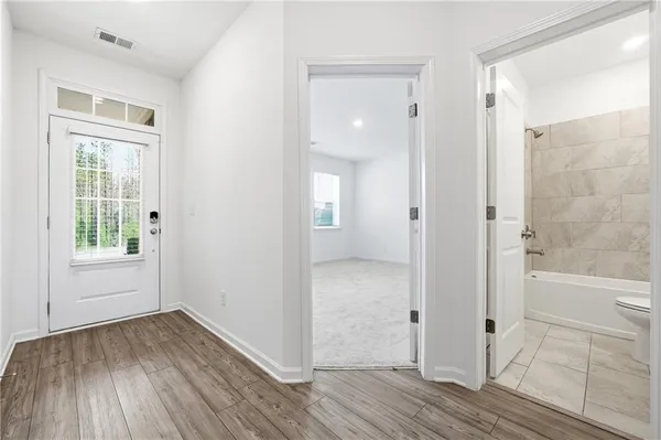 an empty room with wooden floor and a bathroom