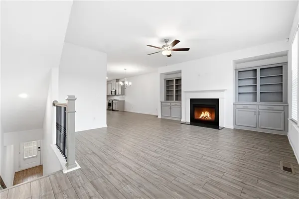 a view of empty room with wooden floor and fireplace