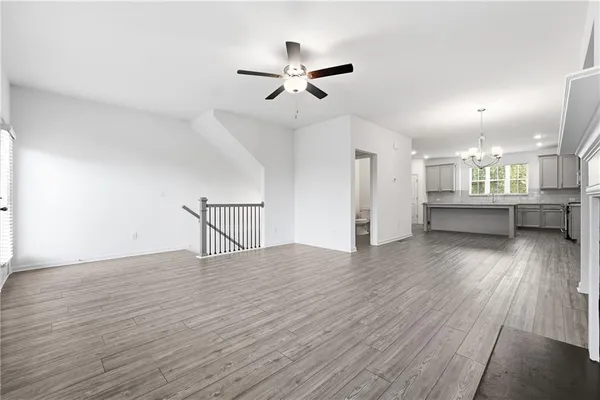 a view of a livingroom with wooden floor and a ceiling fan