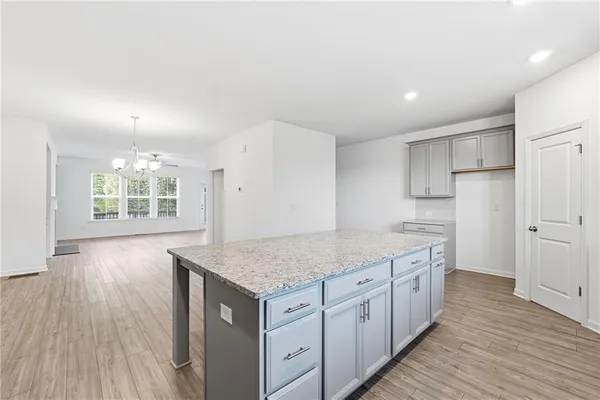 a kitchen with stainless steel appliances granite countertop a kitchen island a hardwood floor and a sink