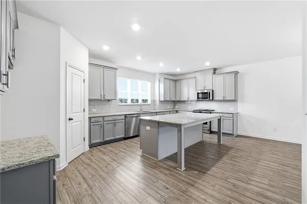 a kitchen with a sink cabinets and wooden floor