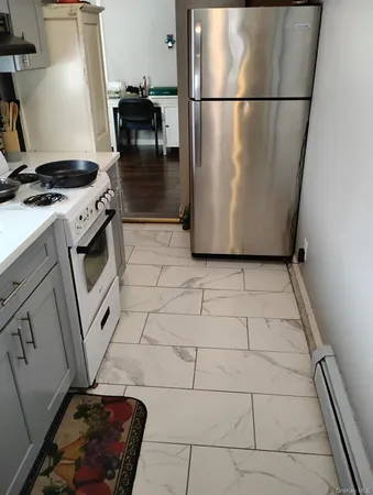 a view of a refrigerator in kitchen and an empty table