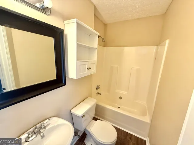 a bathroom with a toilet a sink and bathtub