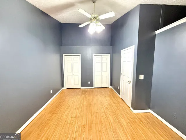 a view of empty room with window and wooden floor