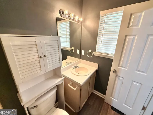 a bathroom with a sink a toilet and a mirror