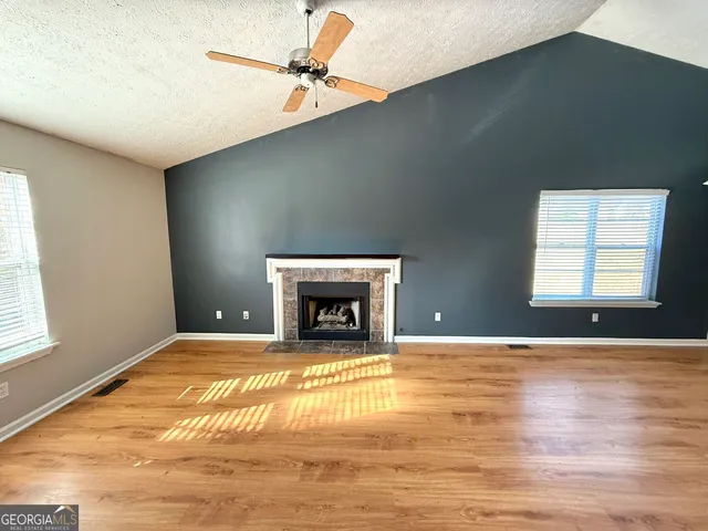 a view of an empty room with a fireplace and a window