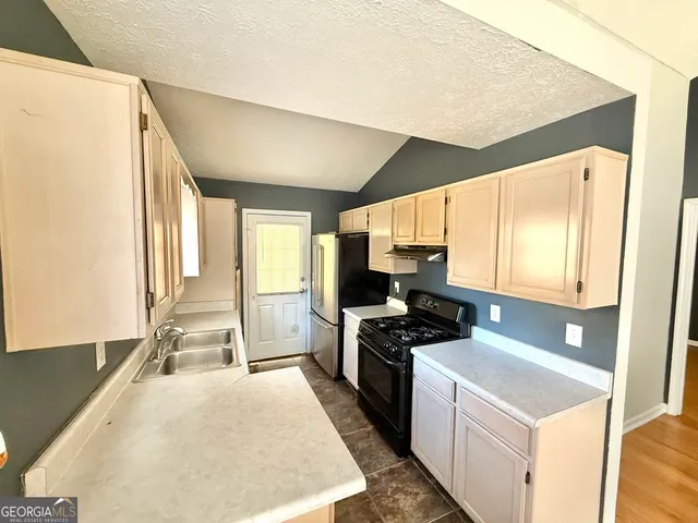 a kitchen with a stove a refrigerator and a sink