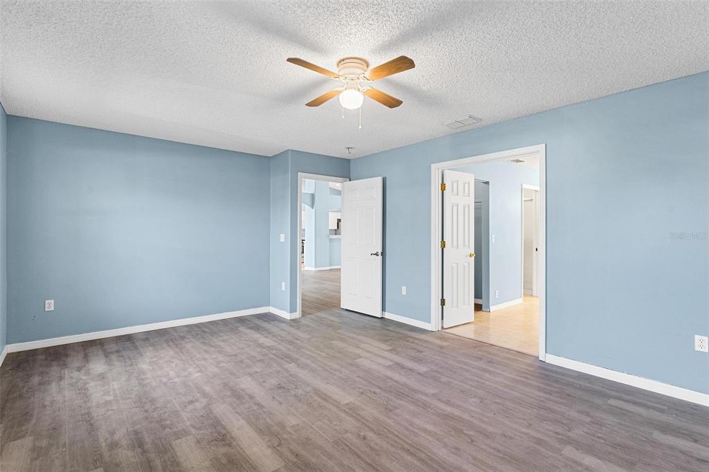 1009 Forest Breeze Path Leesburg, FL 34748 - Photo 14 of 28 a view of an empty room with wooden floor and a ceiling fan