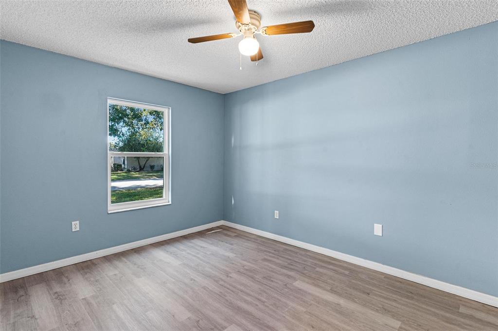 1009 Forest Breeze Path Leesburg, FL 34748 - Photo 17 of 28 wooden floor in an empty room with a window