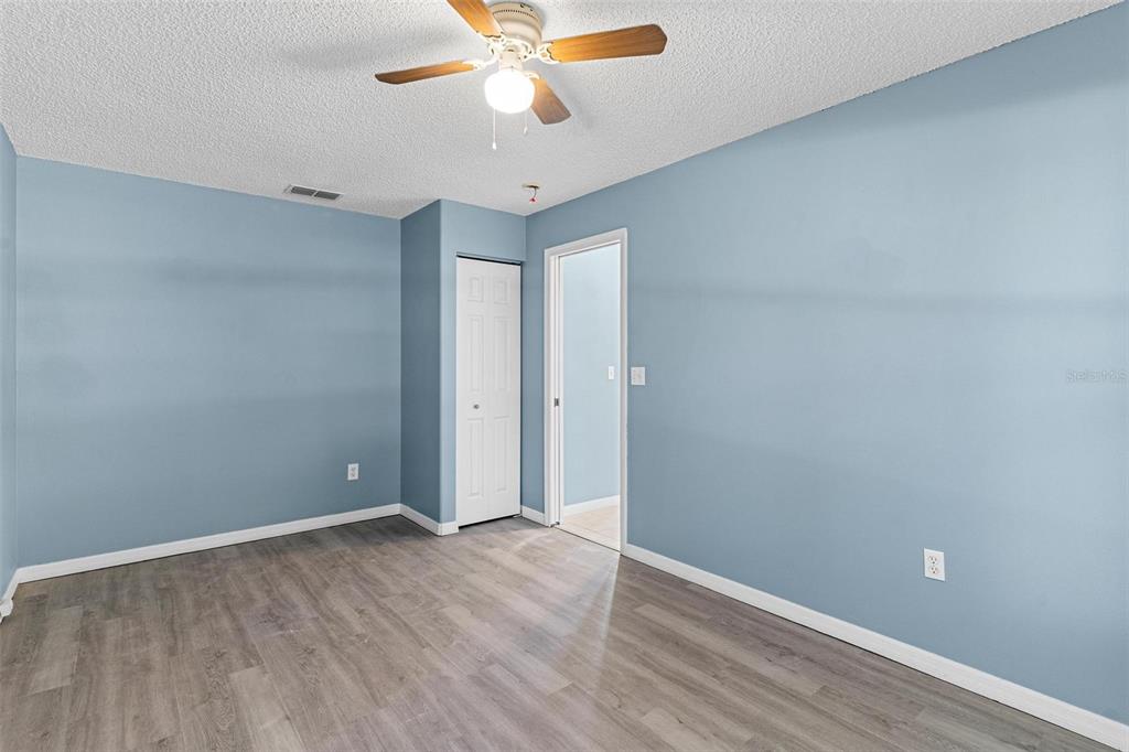 1009 Forest Breeze Path Leesburg, FL 34748 - Photo 18 of 28 an empty room with wooden floor and fan