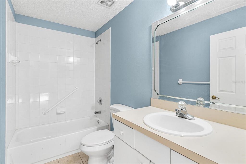 1009 Forest Breeze Path Leesburg, FL 34748 - Photo 19 of 28 a bathroom with a sink a toilet and a large mirror