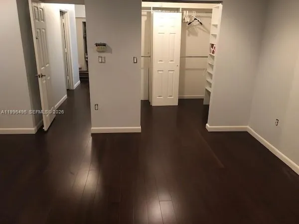 an empty room with wooden floor and entrance