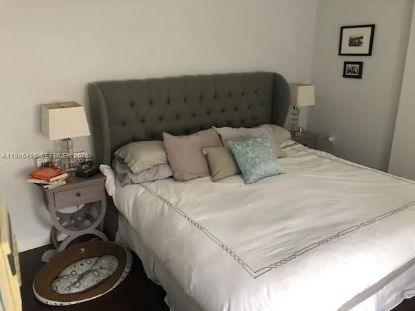 a bedroom with a bed and a lamp on dresser