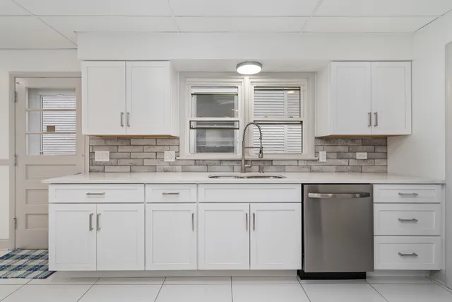 a kitchen with granite countertop white cabinets and a sink