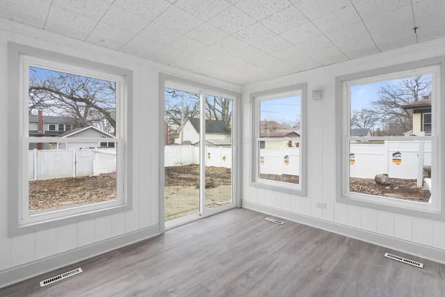 a view of a big room with wooden floor and a window