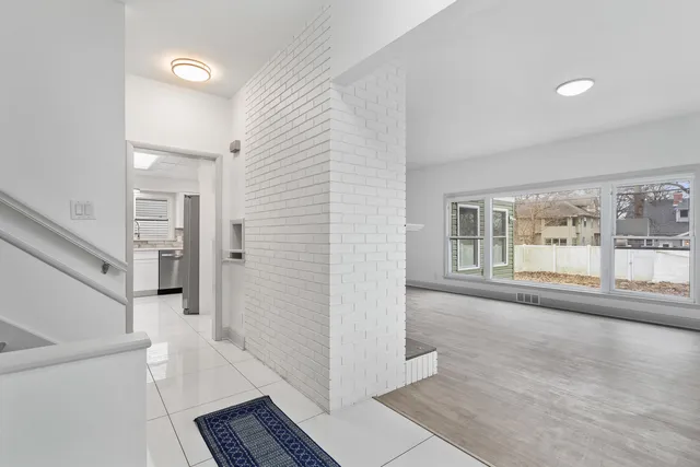 a view of a hallway with wooden floor and a living room