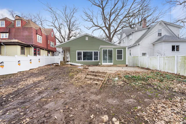 a front view of a house with a yard and potted plants